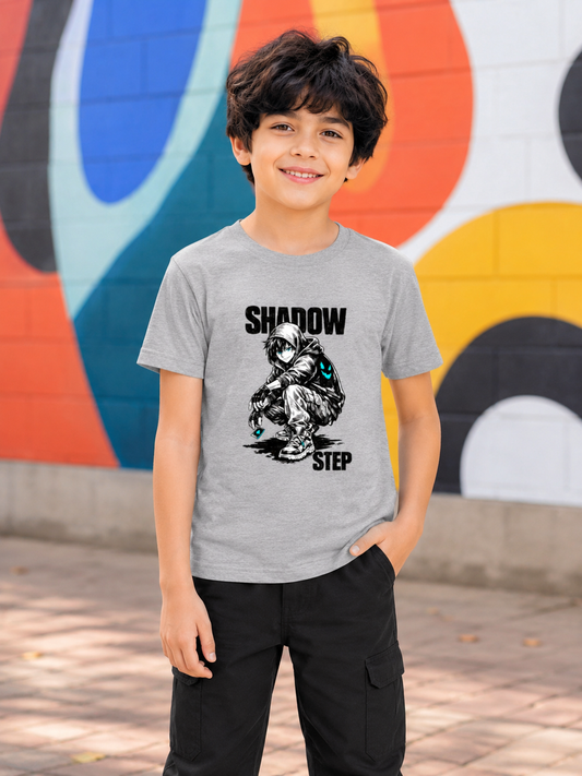 Young boy wearing a gray t-shirt with a graphic design in front of a colorful mural.